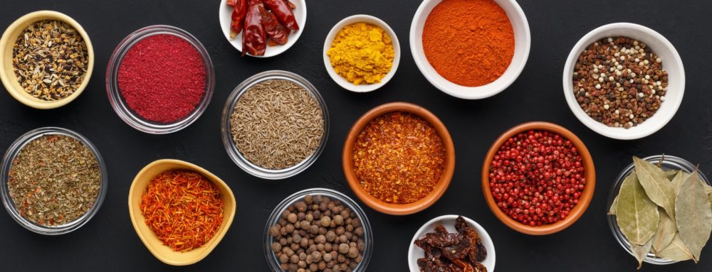 Spice background. Colourful seasonings in bowls, top view