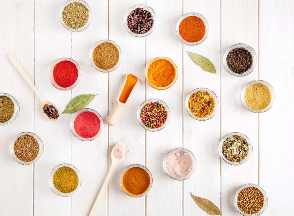 Spices on white wooden background. Food flavor enhancers