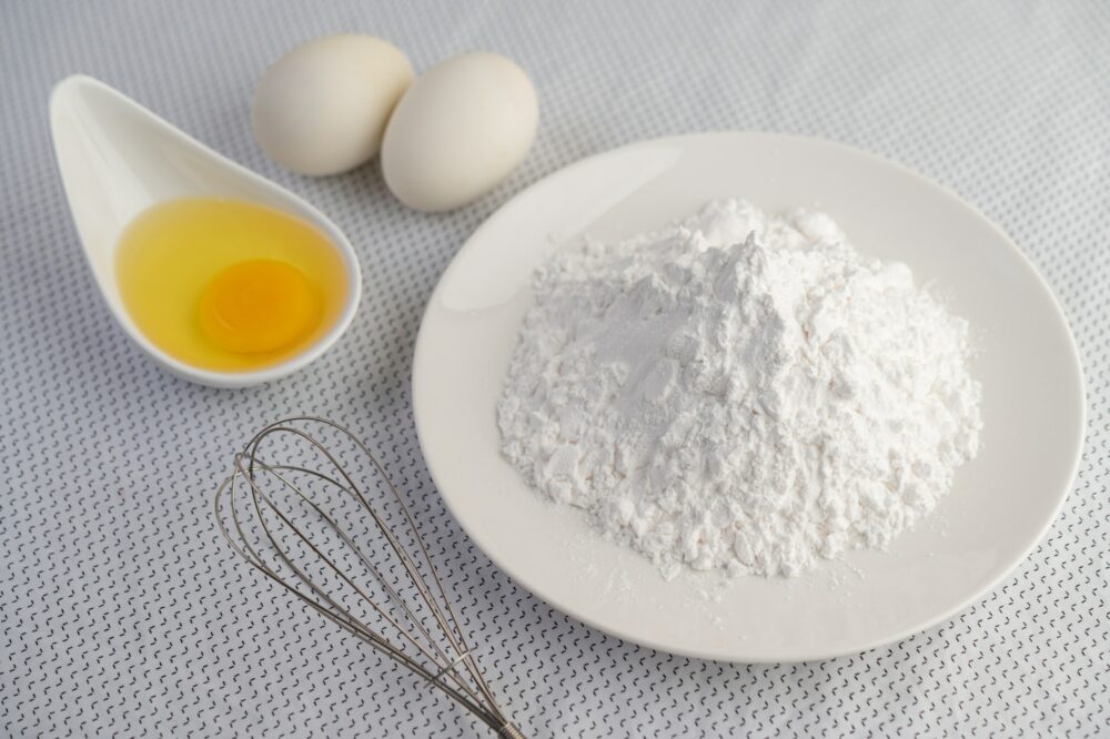 Eggs, tapioca flour and an egg beater, ingredients used in bakery