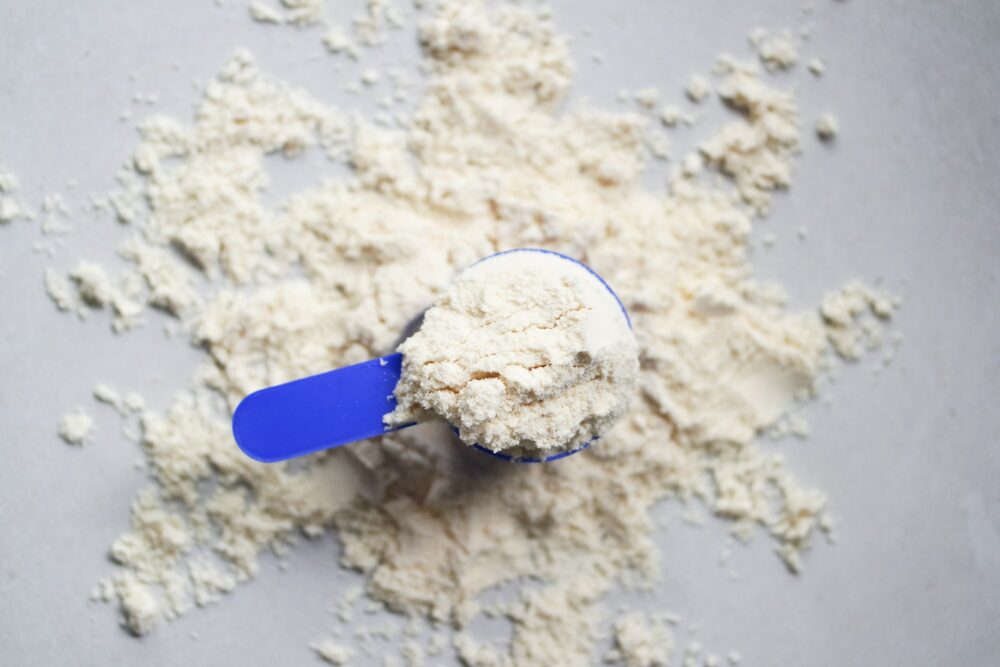 Scoop of whey protein powder. Flat lay powder.