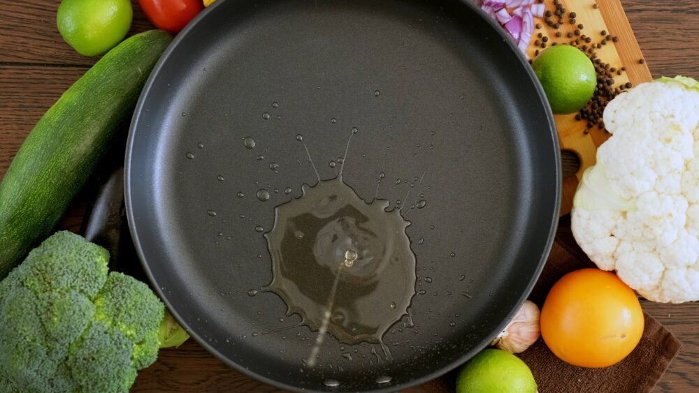 Cook pours sunflower oil into a frying pan